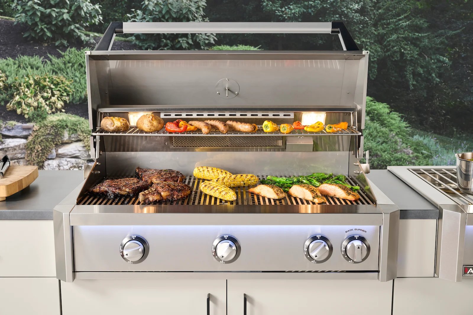 An American Outdoor Grill built-in gas grill in an outdoor kitchen with the hood open