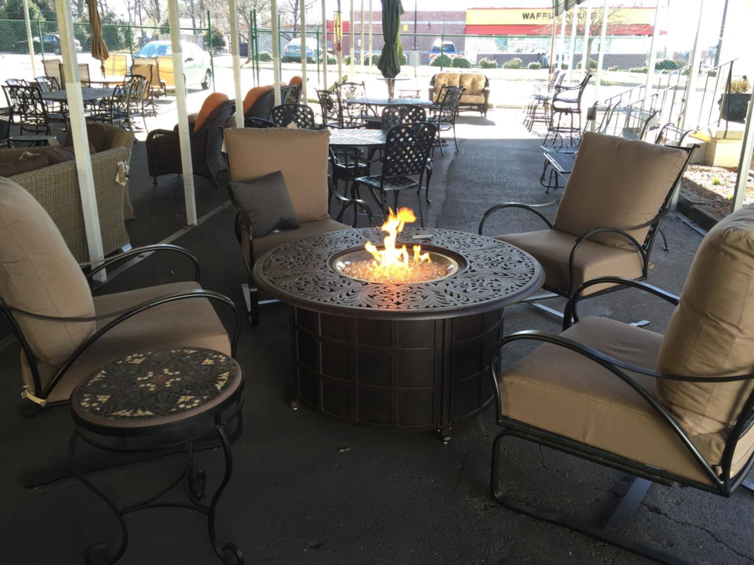 Patio chairs arranged around a lit fire pit table near our front window