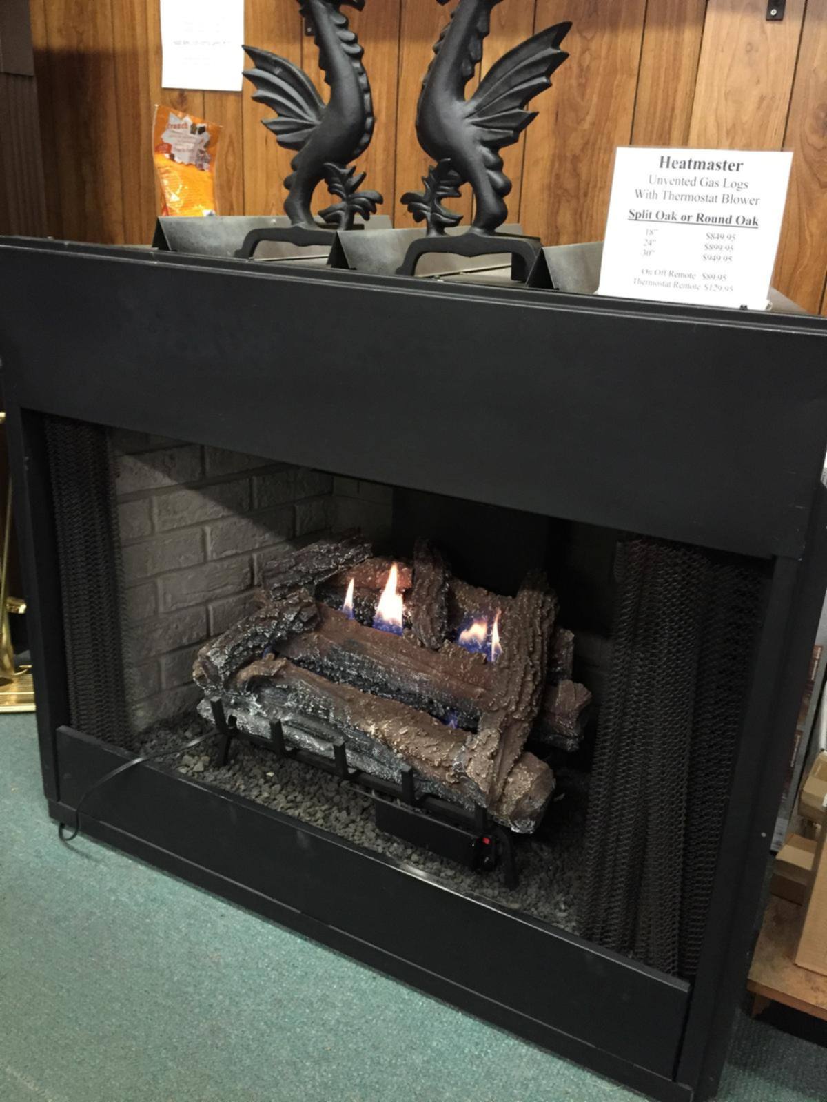 A gas log set burning with cast andirons above